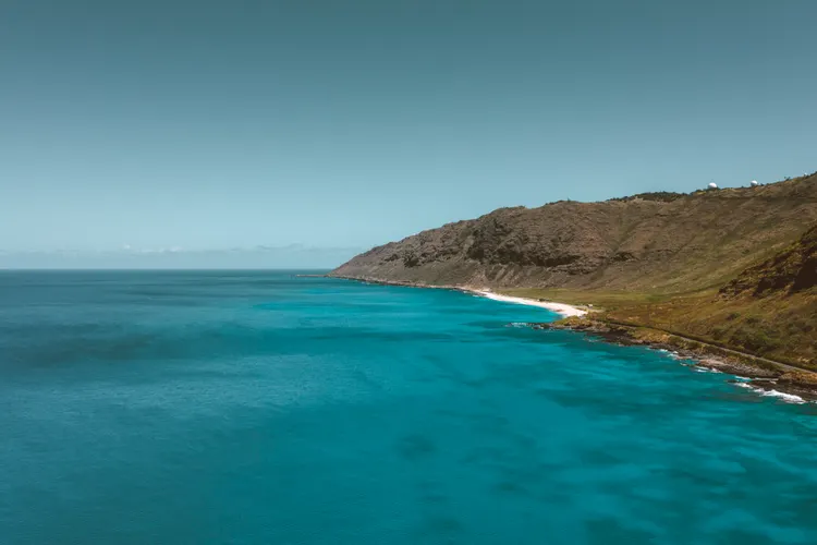 Rugged Oahu lava-rock coastline meeting deep blue ocean at China Walls