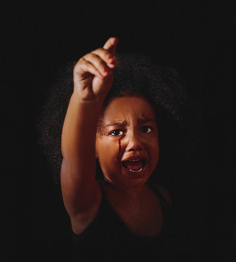 Black Child With Raised Arm Crying On Black Background