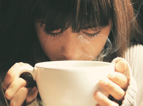 Woman Holding White Cup