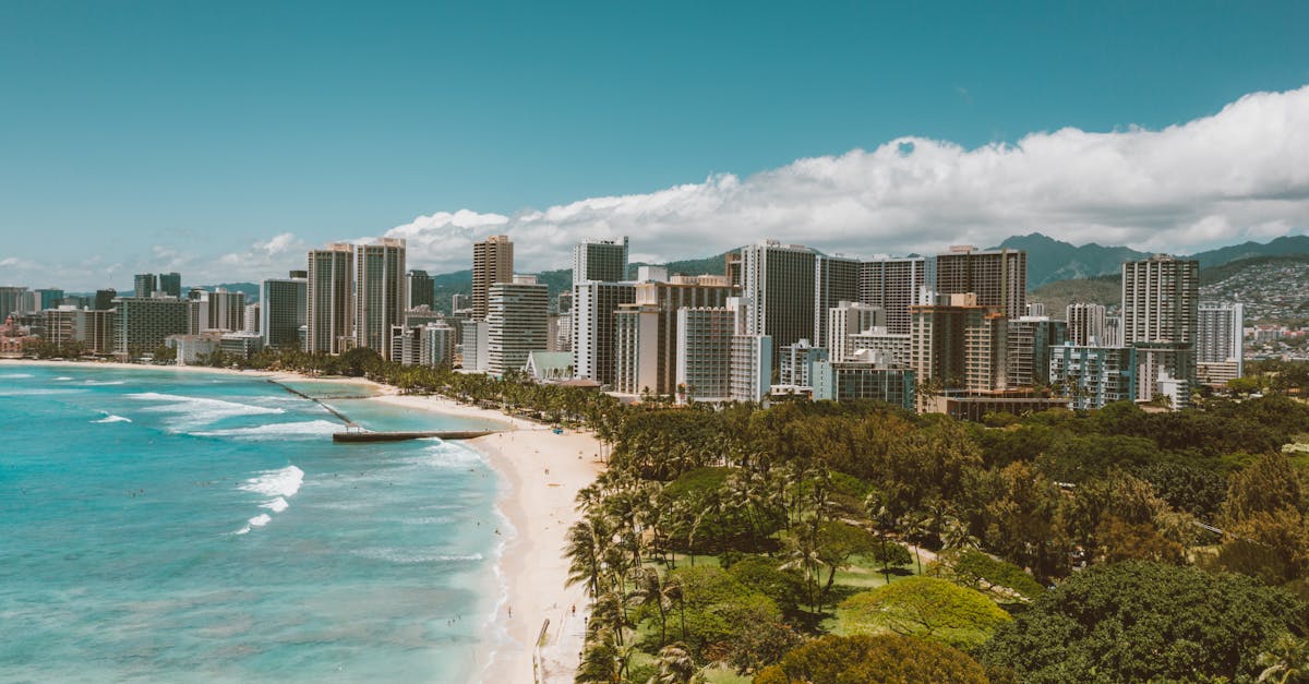 Photo by Jess Loiterton Stunning aerial view of Waikiki Beach and the Honolulu city skyline under clear blue skies.