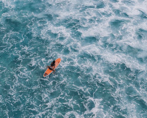 Free Person in Orange Kayak on Blue Body of Water Stock Photo