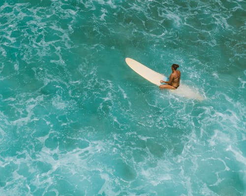 Free Woman in Black Bikini Lying on White Surfboard on Water Stock Photo