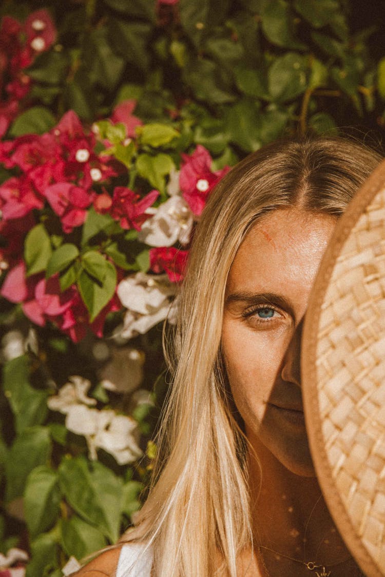 Woman In Brown Sun Hat Near Pink Flowers