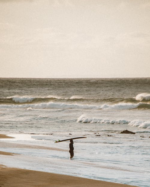 A Surfer Waiting on the Shore 