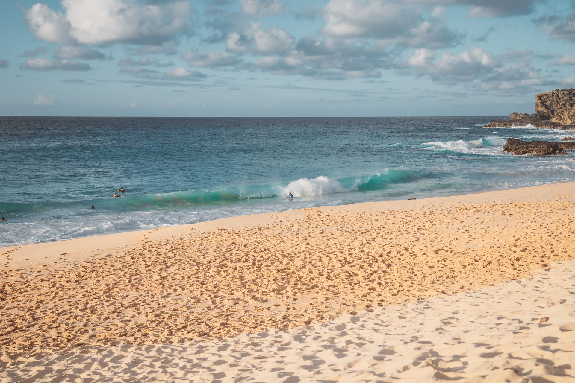 A tranquil Hawaiian beach scene with gentle waves and sandy shores, perfect for a summer getaway.