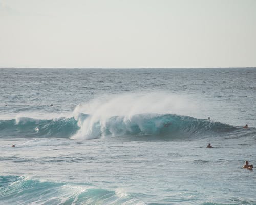 Photo of Sea Wave Crashing with People Swimming 
