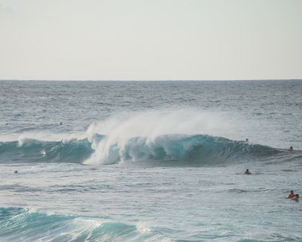 在夏威夷阳光明媚的海滩上，捕捉海浪中的冲浪者
