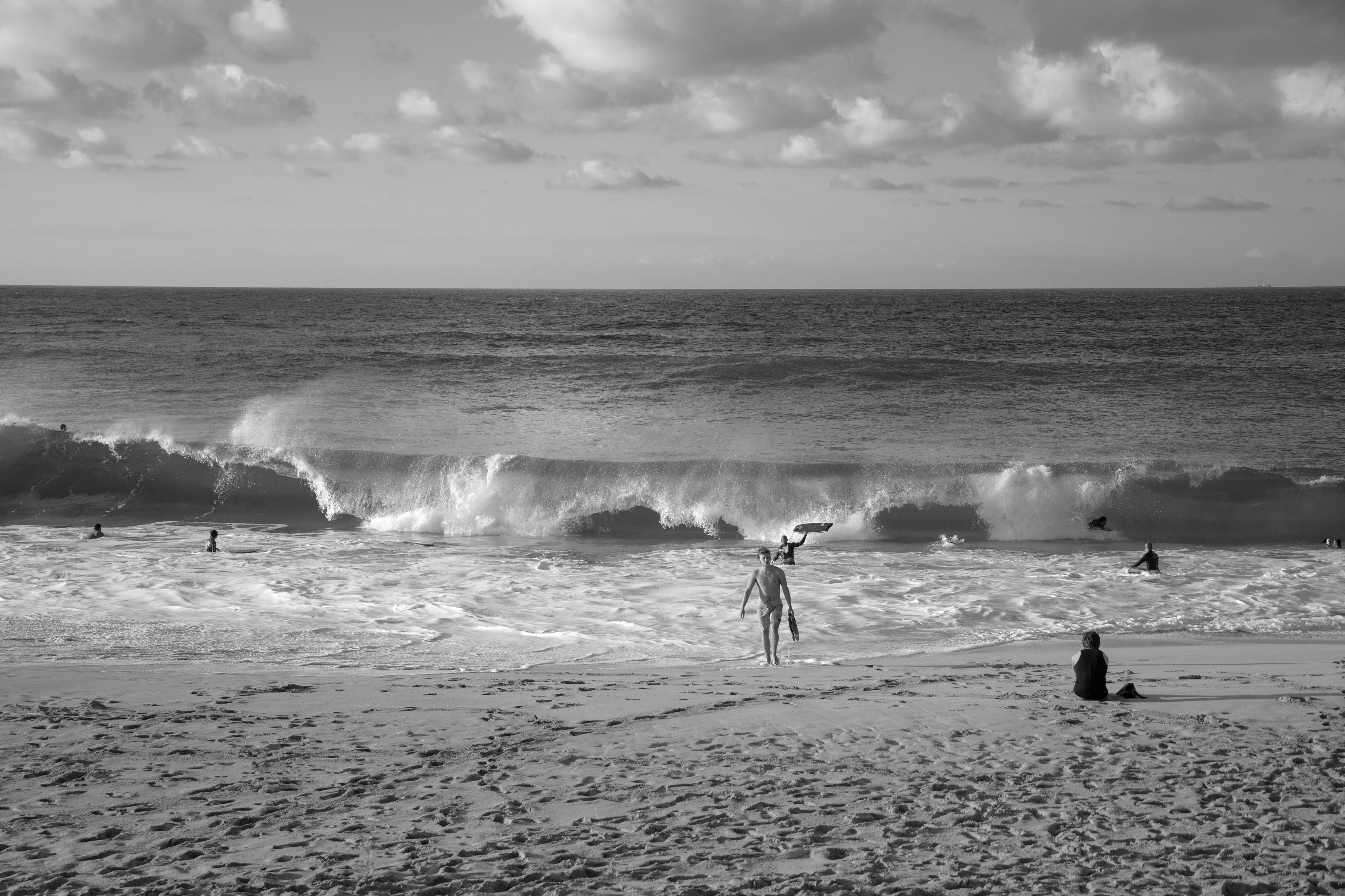 grayscale photo of people on the beach