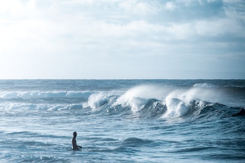 Free Person Standing on Ocean Waves Stock Photo