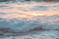 令人着迷的海浪场景反射了充满活力的晚霞，营造出宁静的海滩氛围