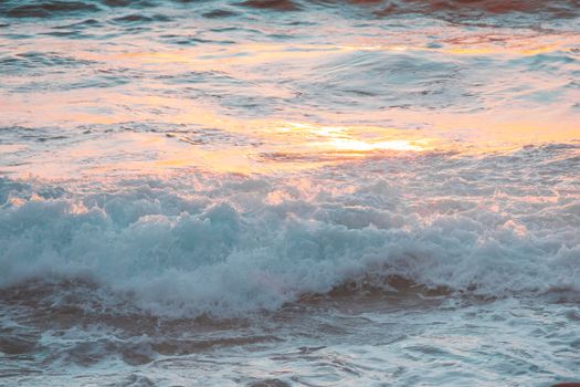 夕阳的绚烂光芒映照在海浪上，营造出宁静的海滩氛围