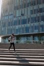 一名戴着口罩的男子走过一栋现代办公楼