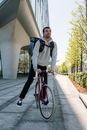 Man in Black Jacket and Black Pants Riding Red Bicycle