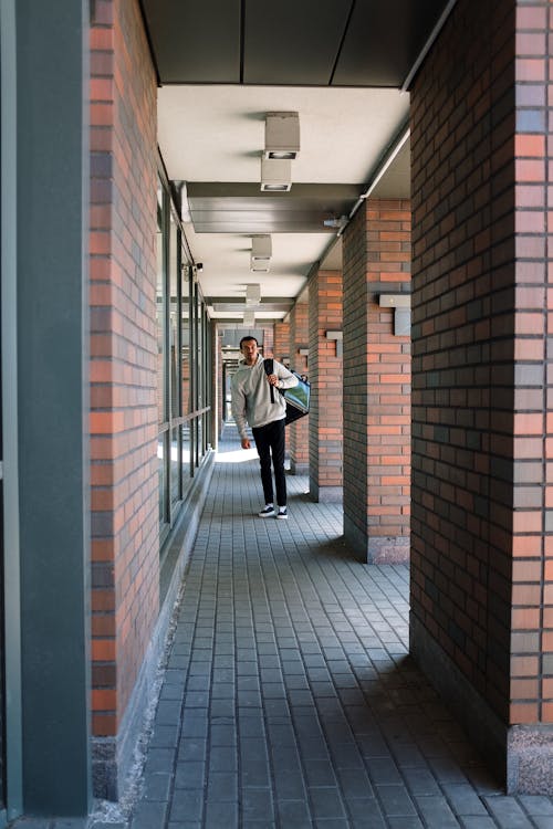 Man in White Dress Shirt Walking on Hallway