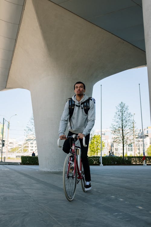 Man in Black Jacket Riding on Red Bicycle