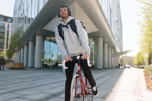 Man in Gray Sweater Riding Red Bicycle