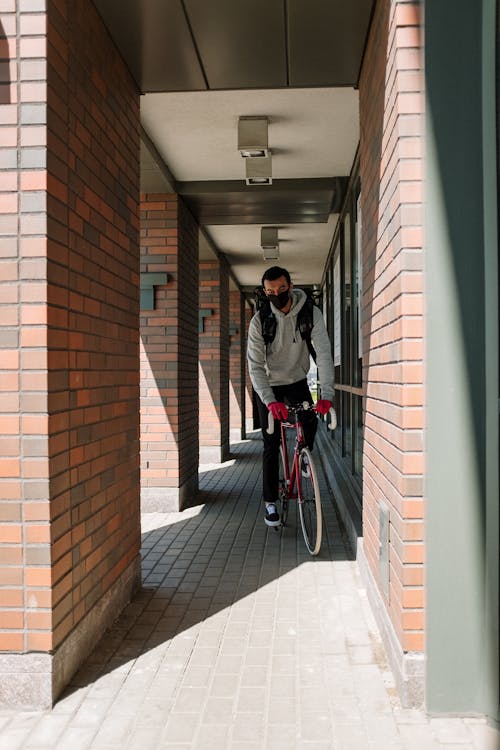 Man in Gray Jacket Riding on Red Bicycle