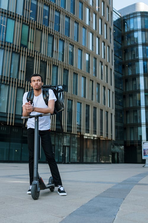 Man in Black Suit Standing on Sidewalk