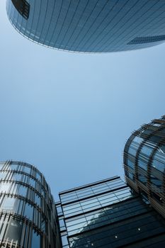 晴朗的蓝天下，圆滑的现代摩天大楼拔地而起，展现了城市建筑的风貌
