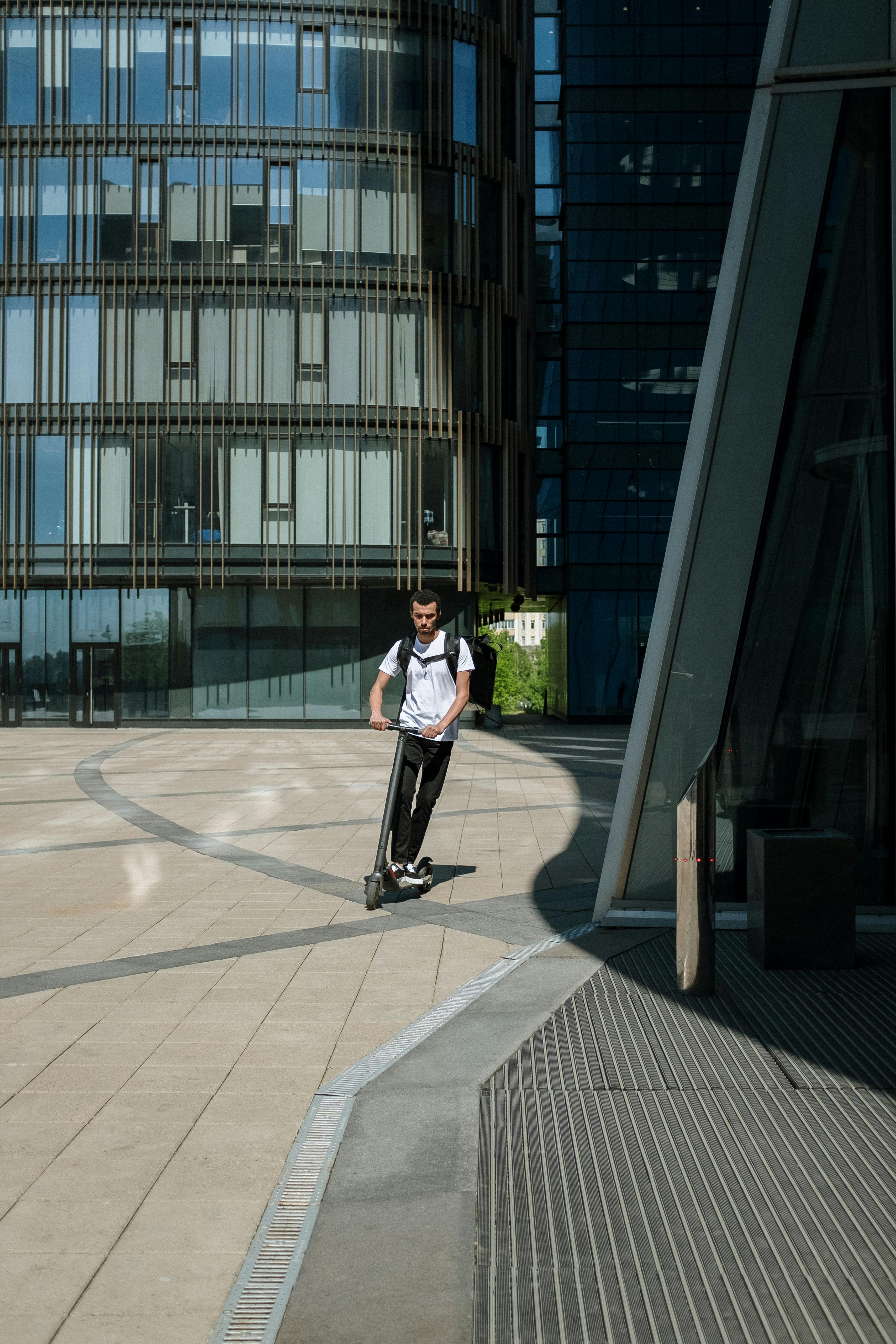 man in white shirt and black pants walking on gray concrete pavement