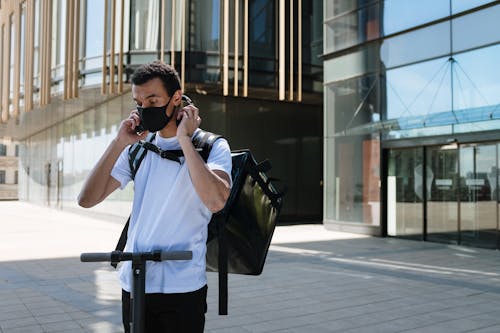 Man in White T-shirt and Black Pants Holding Black Camera