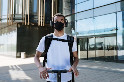 Man in White Crew Neck T-shirt Wearing Black Sunglasses Standing on Sidewalk