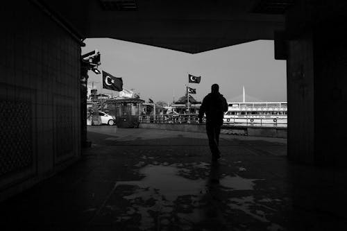 Silhouette of a Man Walking Towards the Port