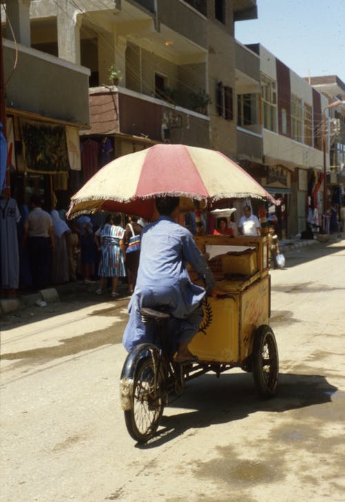 Street Vendor with an Umbrella in His Tricycle