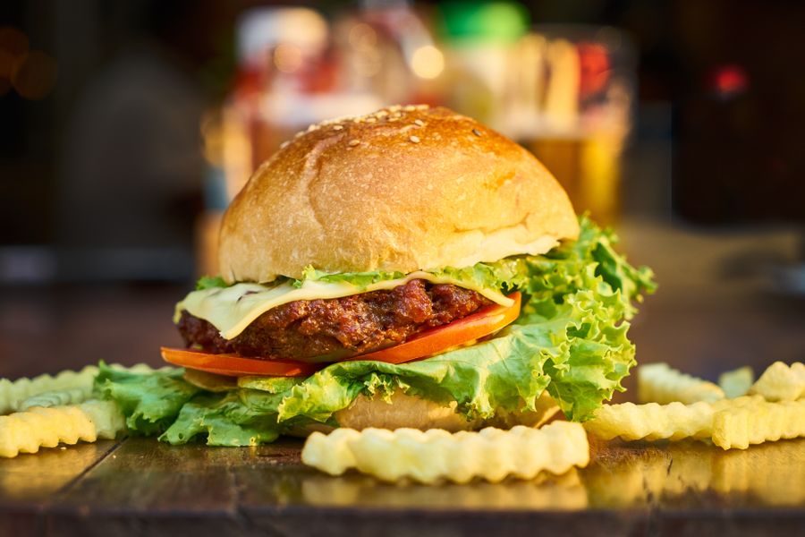 A burger with lettuce and tomato served with fries