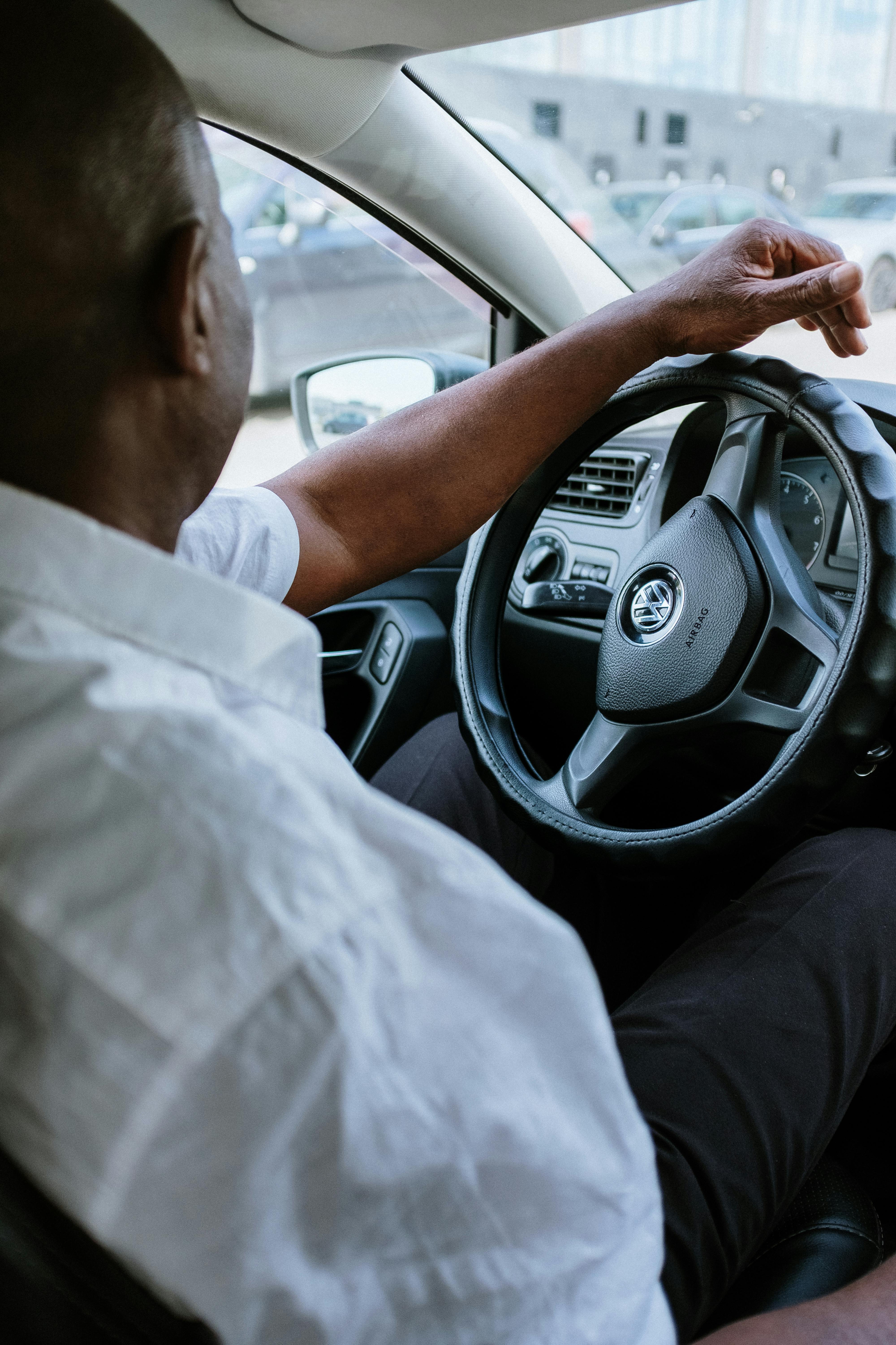 man in white shirt driving car