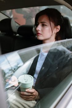 一位体贴的年轻女子在通勤时端着咖啡杯