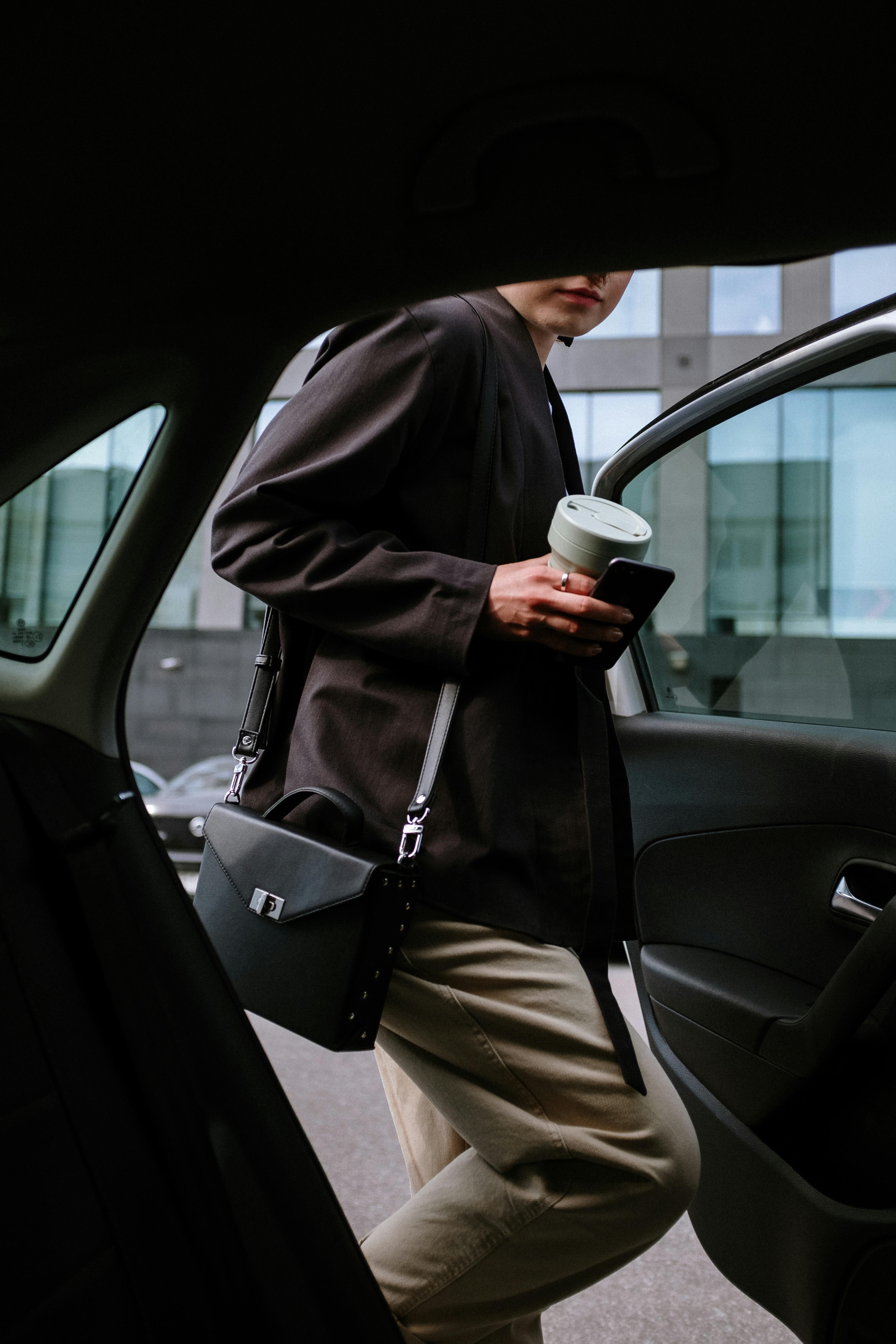 woman in black coat holding white ceramic mug