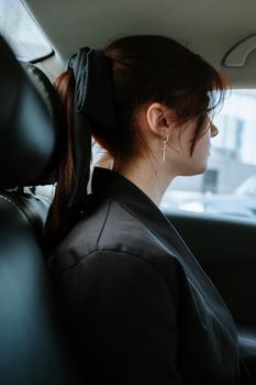 一个女人戴着汽车形状的耳环，展现了现代城市交通的风貌