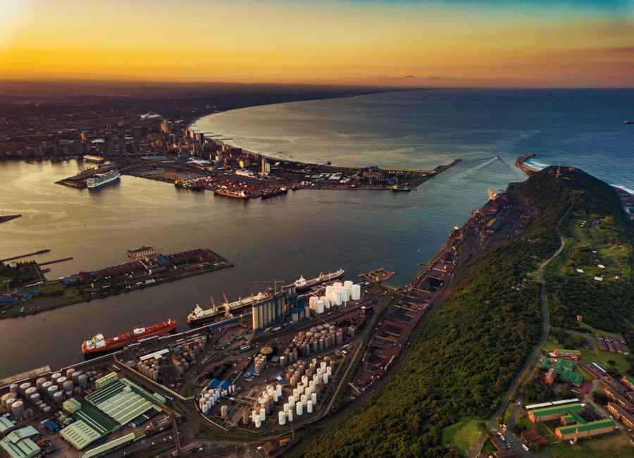 A vibrant aerial view of Durban harbor during sunset showcasing the Indian Ocean and city skyline.