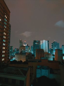 Contemporary high rise modern buildings located in downtown and night gloomy cloudy sky in urban area