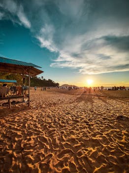 Picturesque scenery of crowded beach with constructions for relax in seashore of resort in sunset