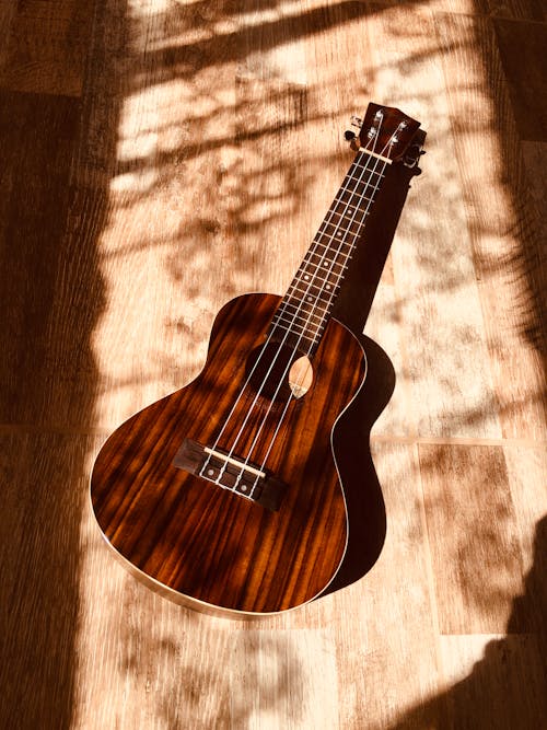 Wooden brown acoustic guitar lying on floor