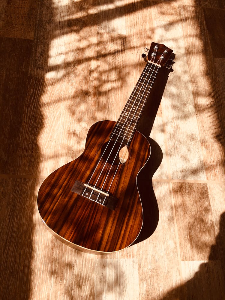 Wooden Brown Acoustic Guitar Lying On Floor