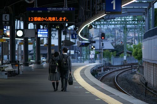 Free A Couple Walking at the Train Station Stock Photo