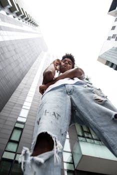 Low angle view of a man standing in front of skyscrapers in Milan.