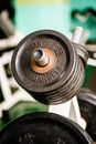 Metal weight plates placed on rack in contemporary fitness center against blurred gym equipment