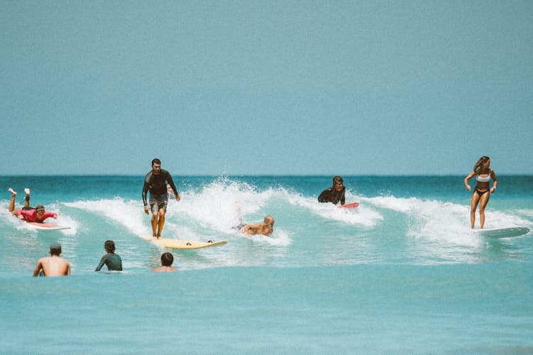 People Surfing On Sea