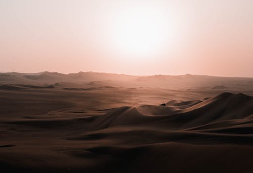 Scenery of car riding over desert dunes