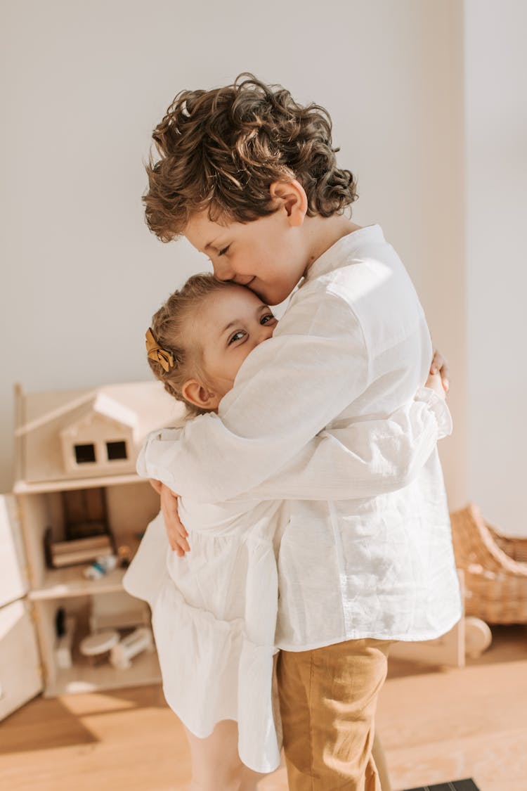 A Brother And Sister Hugging Each Other