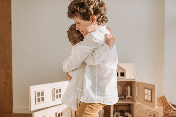 A Brother And Sister Hugging Each Other
