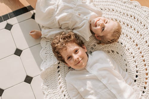 Free Brother and Sister Lying Down on the Floor  Stock Photo