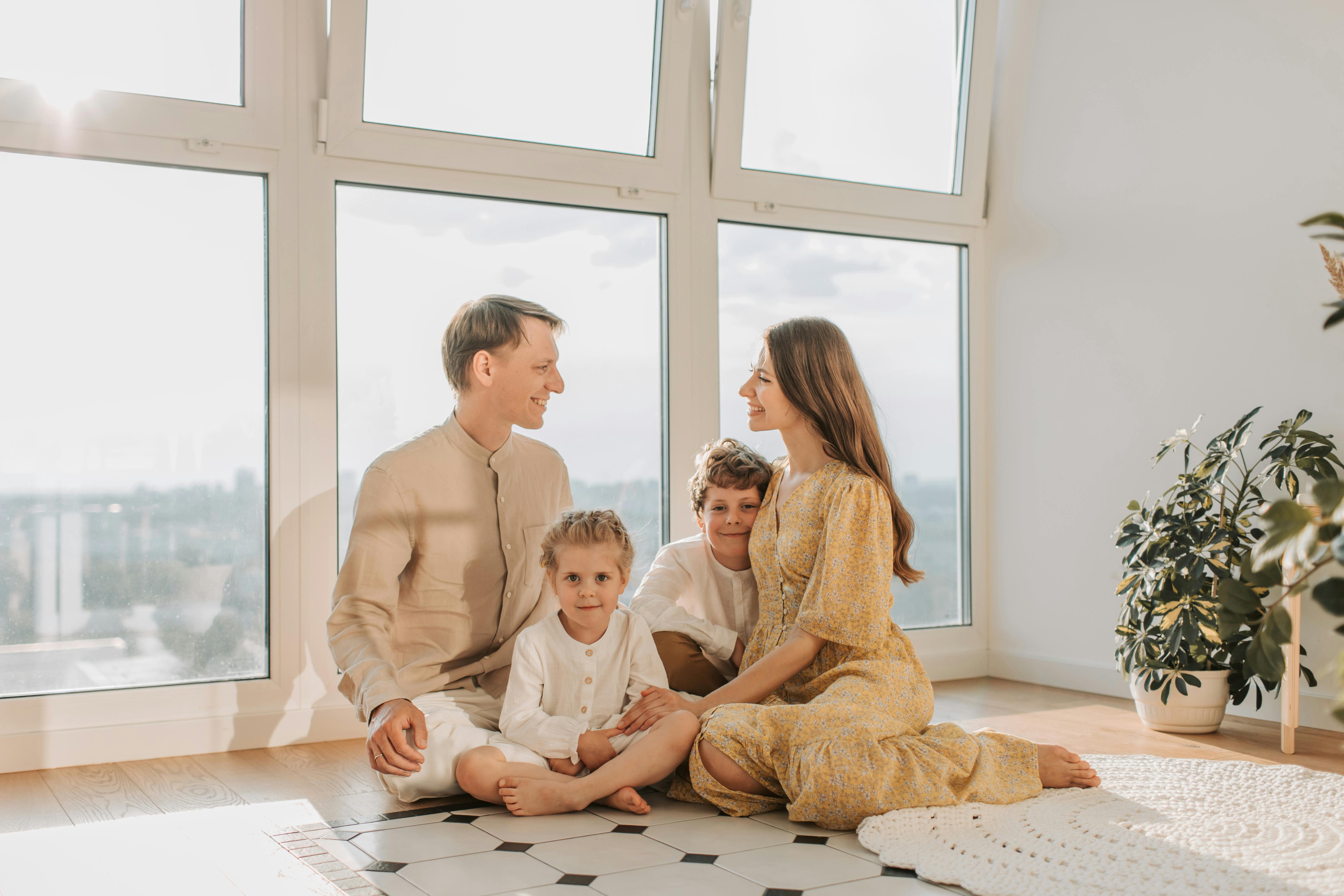 A family comfortably enjoying a sunlit room next to a large, modern energy-efficient window, depicting improved indoor comfort and natural light - energy efficient window upgrades