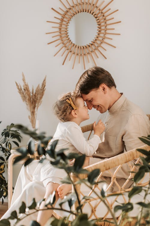 Free A Child Sitting on her Father's Lap Stock Photo