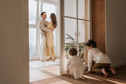 A joyful family moment indoors with parents and children enjoying a cozy home environment.