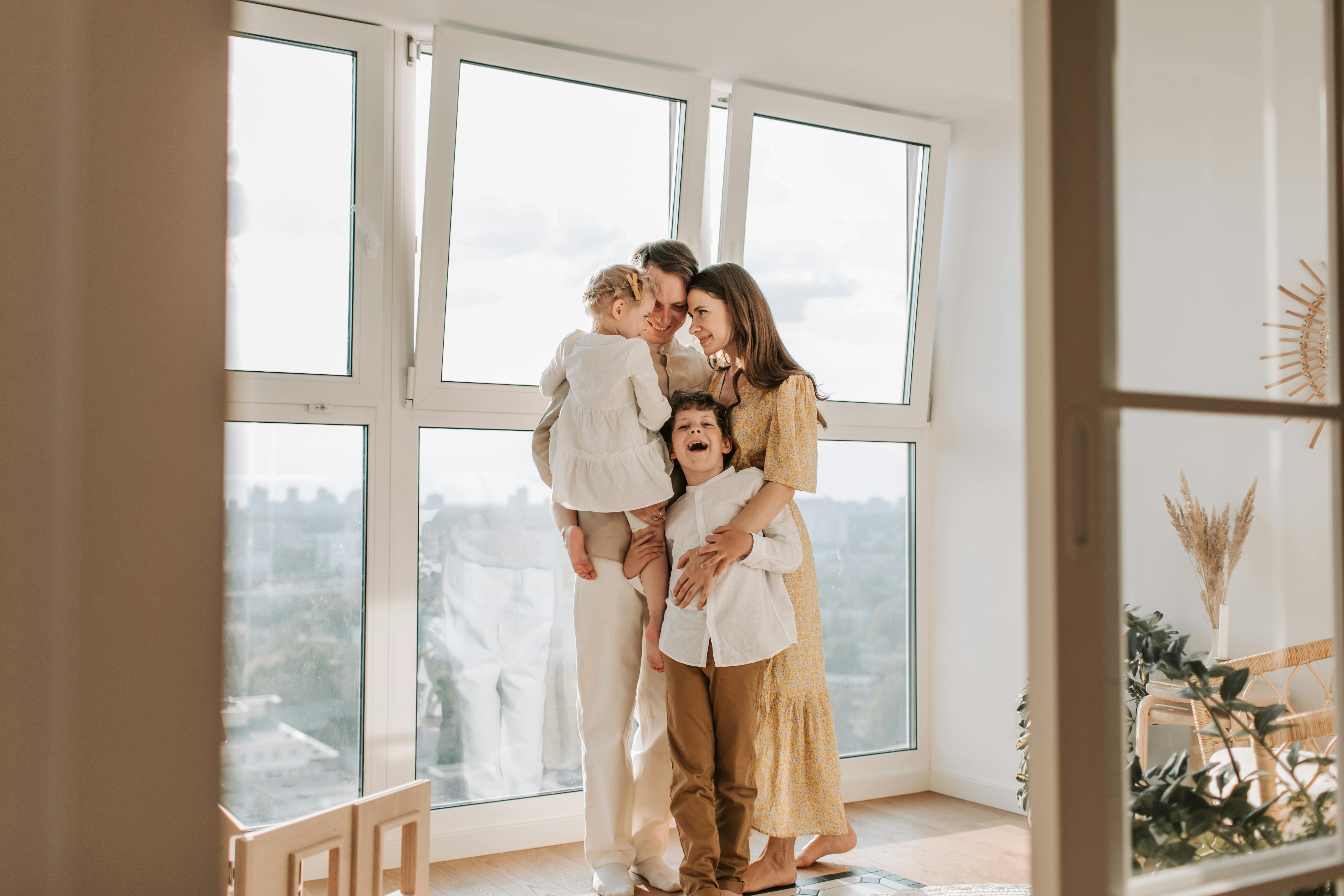 a happy family standing by the window